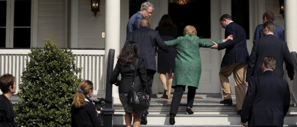 Clinton being helped up stairs