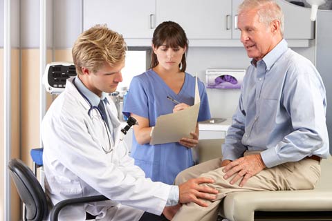 Doctor checking patients knee