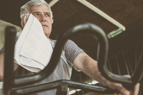 Man on Treadmill Wiping Sweat