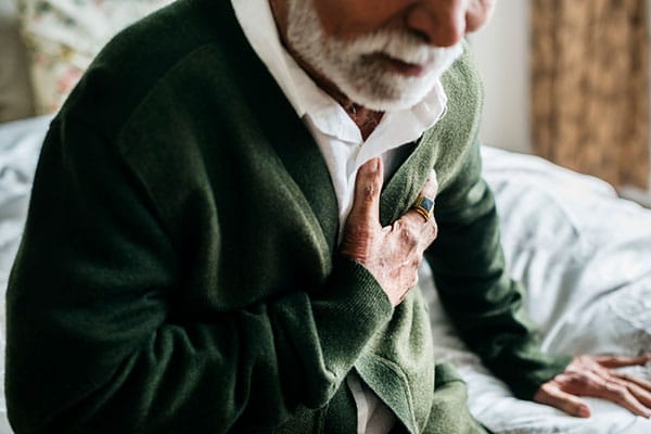 Photo of man grabbing chest.