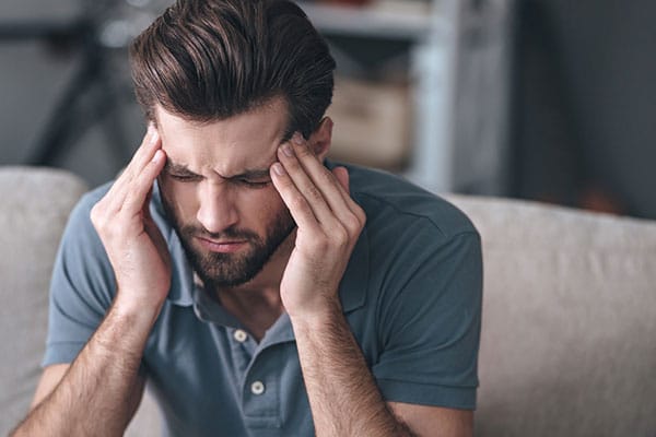 Photo of person rubbing their head.