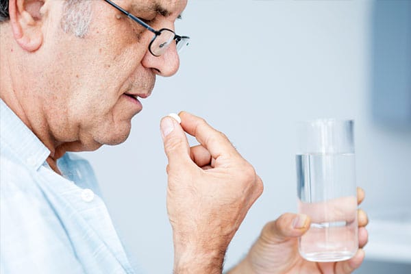 Photo of person taking medicine.