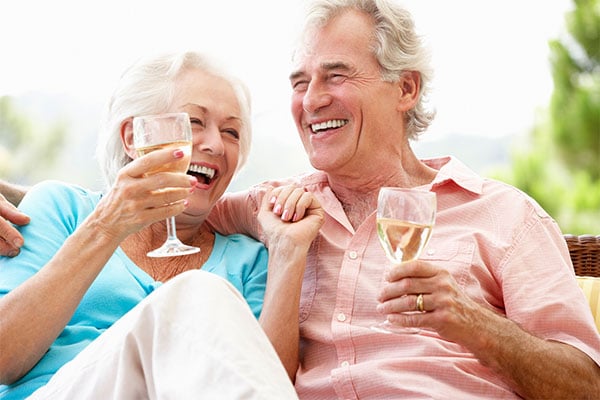 Photo of couple laughing and drinking wine.