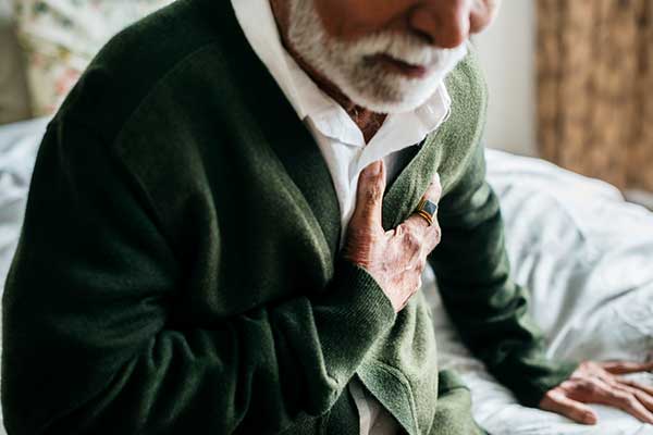 Photo of man grabbing his chest.