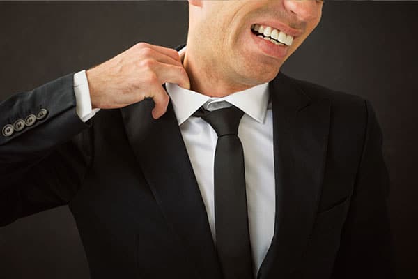 Man Pulling collar of shirt away from neck grimacing.