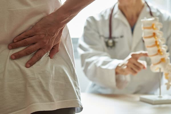 Picture of someone holding back while in front of a doctor.