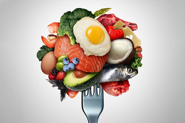 Picture of an arrangement of vegetables and other food on a fork.