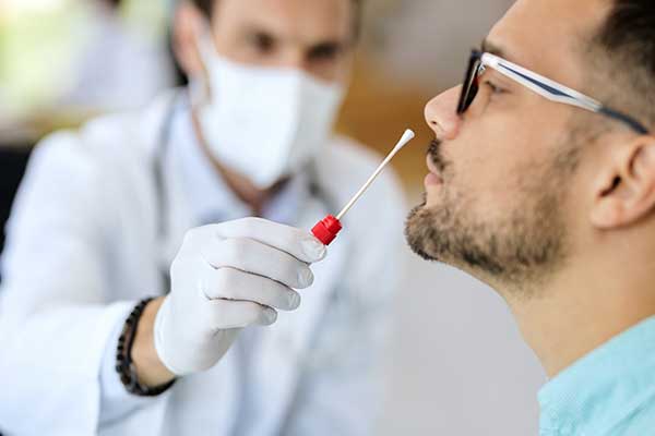 Doctor carrying out a covid nasal test on a patient.