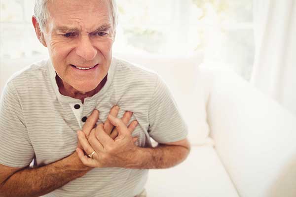 Man clutching chest and grimacing.