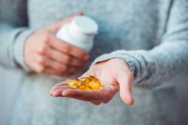 A person holding a hand of pills.